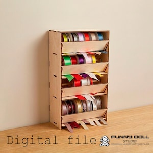 Può includere: Un organizer per nastri in legno con più ripiani, ognuno dei quali contiene bobine di nastri colorati. L'organizer è realizzato in legno chiaro e ha un design semplice e funzionale. Il testo "Digital file" è visibile in basso a sinistra.