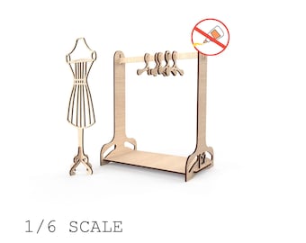 May include: A laser-cut wooden miniature clothing rack with hangers and a dress form. The text "1/6 SCALE Digital file" is displayed below the objects. The image also includes a no-glue symbol.