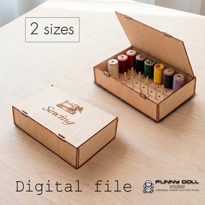 Può includere: Due scatole in legno chiaro per riporre fili. Una scatola è chiusa con la parola Sewing e un'icona di macchina da cucire incisa sul coperchio. L'altra è aperta, rivelando pioli verticali con rocchetti di filo colorati. Testo: 2 sizes e Digital file.