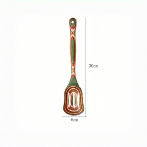 May include: A wooden slotted spatula, 11.8 inches long and 2.4 inches wide, with a green, red, and white striped design. The spatula has a hole in the handle for hanging and is designed for kitchen use.