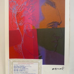 Könnte beinhalten: Ein farbenfroher Andy Warhol-Druck mit einem Porträt in Rot-, Rosa-, Orange-, Lila- und Grüntönen. Der Druck enthält ein Echtheitszertifikat und eine Signatur. Das Kunstwerk ist eine limitierte Auflage, nummeriert 30/100.