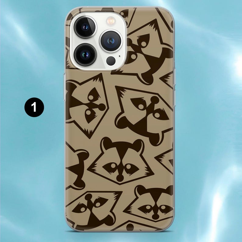 Op de afbeelding: Een smartphonehoesje met een herhalend patroon van donkerbruine wasbeertjes op een beige achtergrond. Het hoesje heeft een uitsparing voor een camerasysteem met drie lenzen aan de linkerbovenkant en het cijfer &eacute;&eacute;n in een zwarte cirkel links.