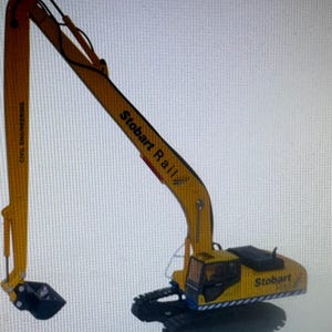 May include: A yellow and black toy excavator with the text "Stobart Rail" and "Civil Engineering" printed on the arm. The excavator has a black bucket and a black base.