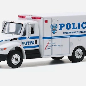 Puede incluir: Un modelo de camión de servicio de emergencia de la policía de Nueva York blanco con detalles en azul y rojo. El camión presenta las palabras "POLICE" y "EMERGENCY SERVICE" en azul, junto con el logotipo de la policía de Nueva York. El lateral del camión también muestra "Cortesía, Profesionalismo, Respeto."