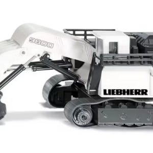 May include: A white and gray Liebherr 9800 model excavator toy. The toy features a large bucket, tracks, and the Liebherr logo. The excavator is designed with a detailed, realistic appearance.