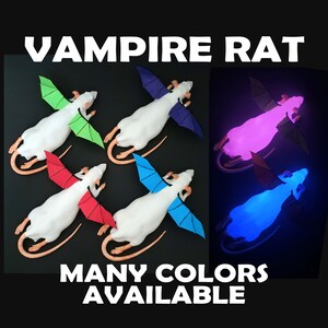 May include: Four white rat figurines with bat-like wings in green, purple, red, and blue, plus two glowing versions in pink and blue. The text reads VAMPIRE RAT and MANY COLORS AVAILABLE. These figures feature long tails and pointed ears.