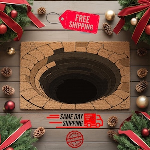 May include: A rectangular doormat with a 3D well design. The mat is brown with a circular well graphic in shades of brown and black. The words "FREE SHIPPING" are on a red tag. Christmas decorations surround the mat.