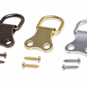 May include: Three metal picture frame hangers in bronze, gold, and silver, each with a D-ring and two screws. The hangers are designed for easy installation and secure hanging of framed artwork or photos.
