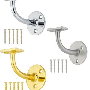 May include: Three metal handrail brackets in chrome, brushed nickel, and gold finishes. Each bracket has a curved arm and a circular base with screw holes. Screws are included with each bracket.