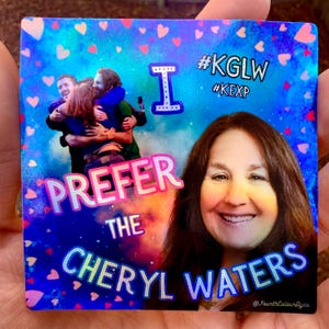 May include: Square sticker with a blue background and a photo of a smiling woman. Text includes "I PREFER THE CHERYL WATERS" and hashtags. The sticker also features a group of people hugging and small pink hearts.