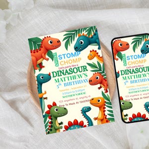 May include: A birthday invitation and a smartphone screen displaying the same design. The design features colorful cartoon dinosaurs, green foliage, and the text "Stomp Chomp" and "Dinasour Matthew's 5th Birthday". The invitation is on a wooden surface.