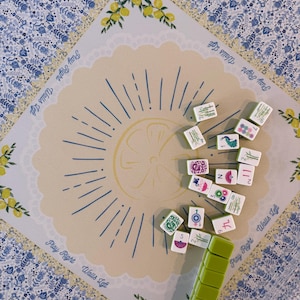 Puede incluir: Vista superior de un juego de Mahjong. El tablero presenta un dise&ntilde;o de lim&oacute;n con el texto "Play Right Walls Left". Las fichas dispersas muestran varios s&iacute;mbolos y n&uacute;meros. Un soporte verde para fichas est&aacute; en primer plano.
