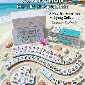 May include: A Getaway Beach Collection American Mahjong set featuring 160 white tiles with colorful coastal illustrations, a storage box, a reference card, and two clear acrylic tile racks, all displayed on a sandy beach with seashells.