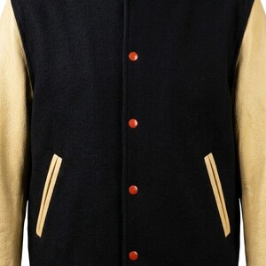 Chaqueta universitaria de piel de vaca negra para hombre, estilo universitario, con bordados color crema y mangas de cuero.