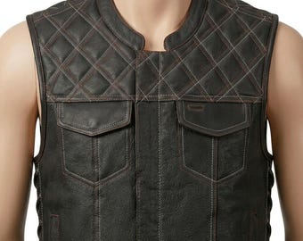 May include: A dark brown leather vest featuring a quilted diamond pattern across the upper chest and shoulders. The garment includes two chest pockets with flaps, a round neckline, and visible contrast stitching throughout the front panels.