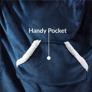 Peut inclure: Gros plan d'une couverture portable bleu marine avec une grande poche avant. La poche est bord&eacute;e d'un mat&eacute;riau blanc et duveteux. Le texte "Handy Pocket" est au-dessus de la poche.