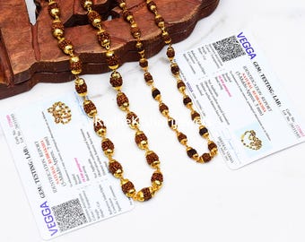 May include: A necklace featuring brown, textured, spherical rudraksha beads alternating with small, polished gold-toned metal beads. The necklace is displayed alongside two white identification reports from Vegga Gems Testing Labs.