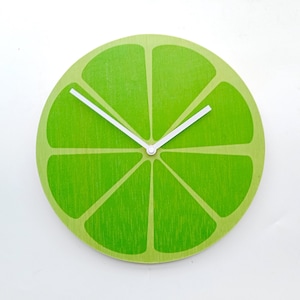 May include: A green lime-shaped wall clock with white hands.