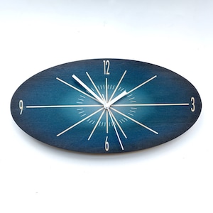 Oval Dark Blue Fade Wooden Wall Clock. Unique colourful mid century modern silent analog clock for the kitchen, living room or bedroom.