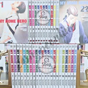Peut inclure: Une collection de 22 volumes de manga intitulée "MY HOME HERO" est présentée. Les couvertures présentent des illustrations de personnages et le titre de la série. Les dos sont codés par couleur. Les livres sont rangés sur une étagère.
