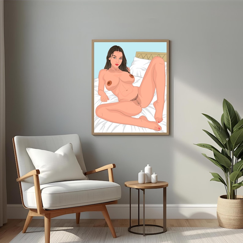 May include: A framed art print featuring a nude illustration of a person reclining on a bed. The artwork depicts a person with brown hair and red lips, set against a light blue background. The print is displayed in a room with a chair, side table, and a potted plant.
