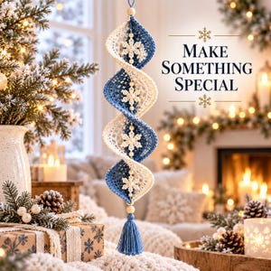 May include: A hanging spiral ornament featuring alternating blue and white crocheted sections, accented with white snowflake motifs and small beads. The ornament terminates in a blue tassel and includes the text MAKE SOMETHING SPECIAL.