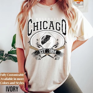 May include: Ivory-colored t-shirt featuring a baseball-themed graphic. The design includes the word "CHICAGO" in a bold, distressed font, with "BASEBALL" above and "EST. 1894" below. A baseball and crossed bats complete the design. The text "Fully Customizable Available in more Colors and Styles" is also visible.