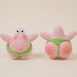 May include: Two handmade crochet figures of a pink starfish character. One figure faces forward with white eyes and black pupils, wearing a lime green waistband. The other figure faces backward, showing the back of the lime green waistband.
