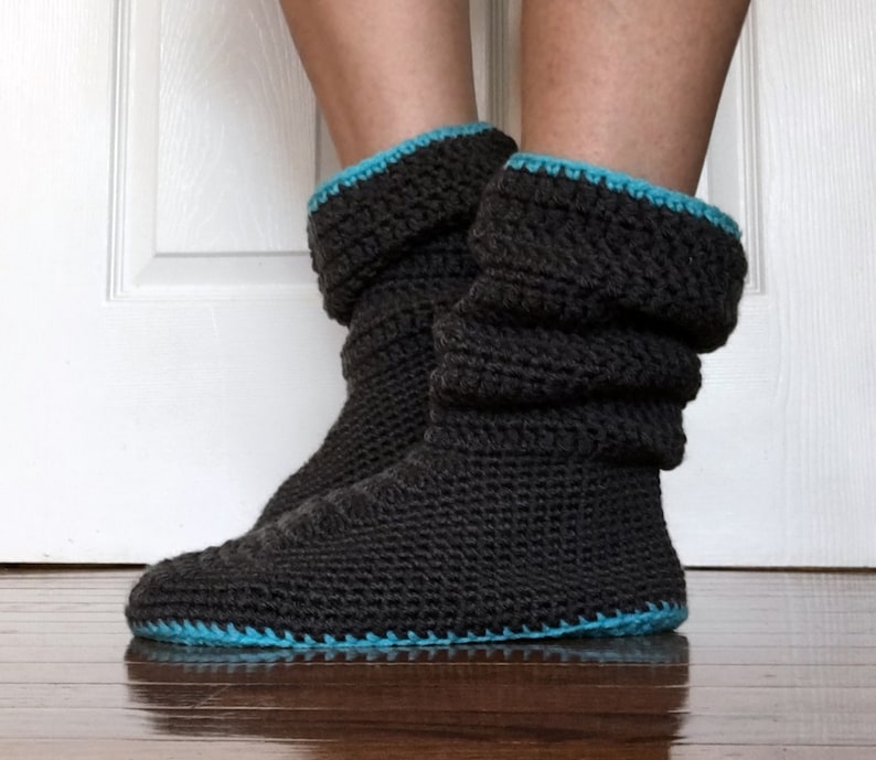 May include: Gray crocheted slipper boots with a turquoise trim. The boots are slouchy and have a fold-over cuff.