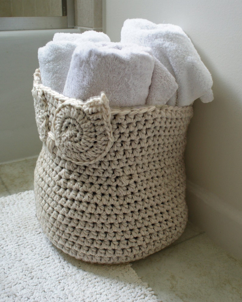 May include: A crocheted owl-shaped basket filled with white towels in a bathroom setting.