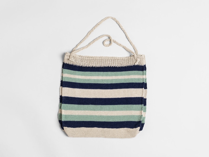 May include: A striped knitted tote bag with a cream, blue, and green color scheme. The bag has a single strap.