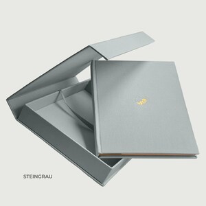 Personalisierte Babyalbum-Seite aus dem Erinnerungsalbum „Piccolo“ mit transparentem, seidigem Vellumblatt. Gezeigt wird die individuelle Heißfolienprägung mit Sternzeichen-Symbol, Vor- und Nachname des Babys sowie dem Geburtsdatum. Die zarte Goldprägung liegt über der ersten Seite des Babybuchs und macht das Album zu einem persönlichen Geschenk zur Geburt, Taufe oder Babyparty. Ideal als hochwertiges Erinnerungsbuch für Neugeborene und Eltern