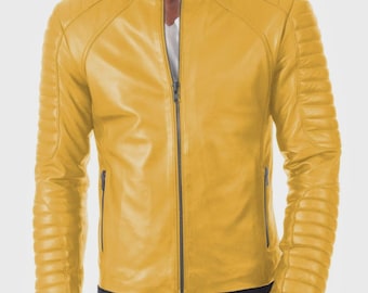 Könnte beinhalten: Senfgelbe Lederjacke mit Stehkragen und durchgehendem Reißverschluss. Die Jacke hat Steppdetails an Schultern und Ärmeln sowie zwei Reißverschlusstaschen. Das Model trägt ein weißes Hemd und dunkelblaue Jeans.