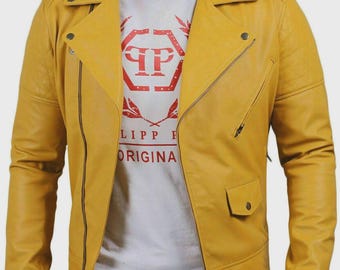 Könnte beinhalten: Senfgelbe Lederjacke mit asymmetrischem Reißverschluss. Sie hat einen Reverskragen, mehrere Taschen und einen Reißverschluss. Ein weißes T-Shirt mit rotem Text ist darunter sichtbar. Die Jacke ist etwa 60 cm lang.