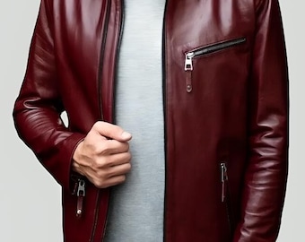 Puede incluir: Chaqueta de cuero burdeos con cuello alzado y múltiples bolsillos con cremallera. La chaqueta tiene cierre de cremallera frontal y un diseño elegante y moderno. La chaqueta es de color rojo oscuro.
