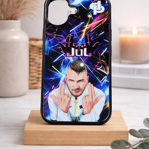 Peut inclure: Coque de téléphone noire avec un portrait d'un homme à la tête rasée, portant une veste blanche et faisant un geste de la main. L'étui a un fond abstrait coloré avec le mot "JUL" en rose.