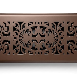 May include: A rectangular brown metal floor register vent cover featuring an intricate laser-cut scrollwork pattern. The design consists of a central oval motif flanked by symmetrical floral-inspired filigree cutouts, creating a decorative grate.