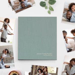 May include: A teal photo album with the text "Jasmine Destiny Sanders Our Beautiful Girl" on the cover. The album is surrounded by photos of a family.