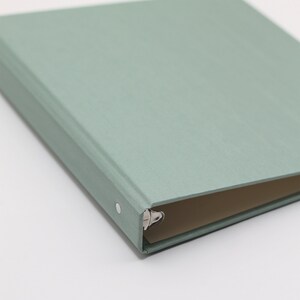 May include: A light green binder with a silver ring mechanism.