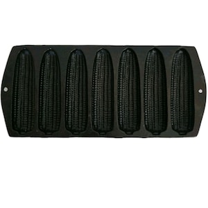May include: A black cast iron cornbread pan shaped like six ears of corn. The pan has a textured surface and is designed for baking. The pan has handles on each side for easy handling.