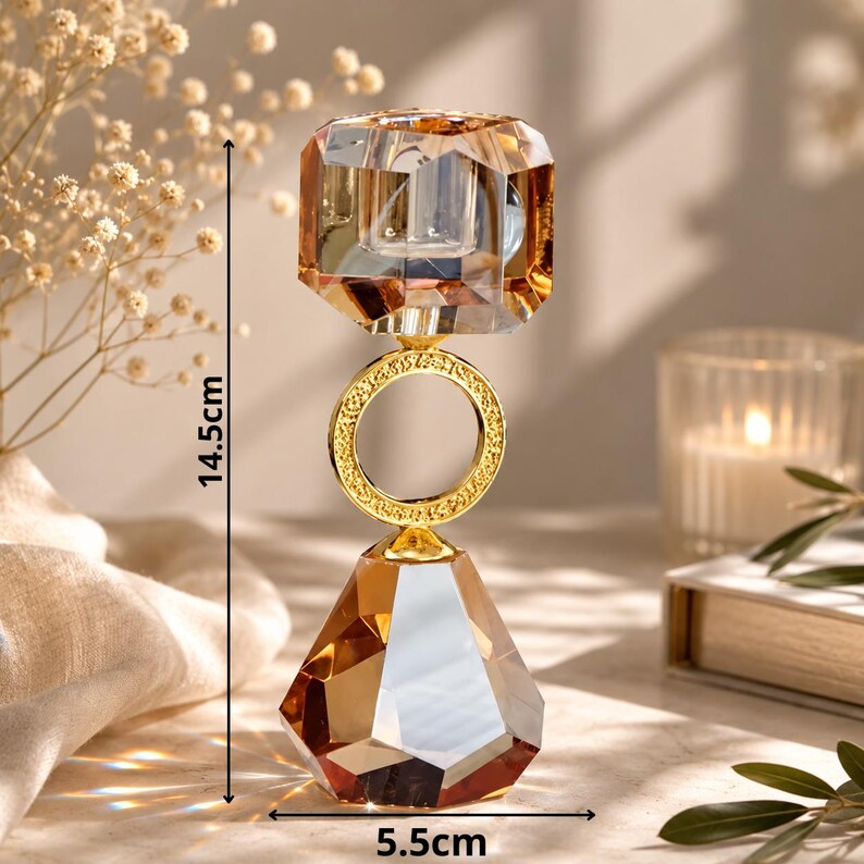 May include: A decorative crystal candle holder, 5.7 inches tall and 2.2 inches wide, with a faceted amber-colored top and base, connected by a gold ring. The candle holder has a gold-colored metal ring and accents.