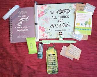 May include: A collection of religious stationery and accessories including a purple spiral notebook with the text For with God nothing shall be impossible, a floral zippered pouch with the text With God all things are possible, a green pen, a small Jesus figurine, a keychain, and several cards with scripture verses.