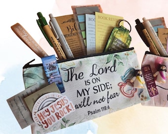 May include: A zippered pouch featuring the text The Lord is on my side; I will not fear Psalm 118:6 and a Hey Jesus You Rock sticker. The pouch contains pens, a bookmark, a book review card, a keychain, and small figurines of Jesus.
