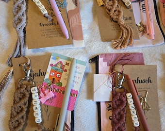 May include: Four macrame keychains with YAHWEH letter beads, each attached to a card featuring Proverbs 18:10 text. Each set includes a colored pen, a small decorative paper clip, and a zippered pouch. The keychains feature tassels and metal clips.