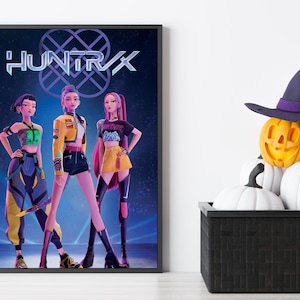 Puede incluir: Póster enmarcado con tres figuras femeninas animadas con atuendos elegantes, con el texto "HUNTXR". Una calabaza tallada con un sombrero de bruja se encuentra encima de una cesta negra llena de calabazas blancas.