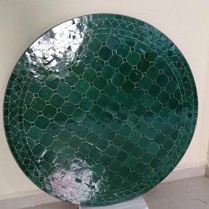 Op de afbeelding: Een ronde tafelblad met mozaïektegels in donkergroen. Het tafelblad heeft een geometrisch patroon van achthoeken en vierkanten, met een donkere rand. Het tafelblad heeft een diameter van ongeveer 91 cm.
