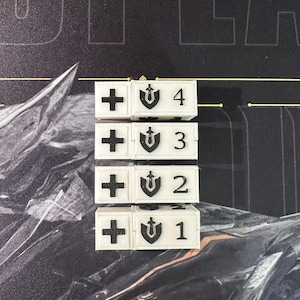 May include: Four white game tokens with black symbols and numbers 1 through 4. Each token has a plus sign, a shield with a sword, and a number. The tokens are arranged in a vertical line.