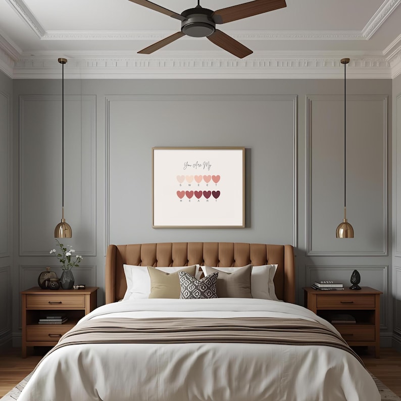 Puede incluir: Interior de dormitorio con una cama con cabecero marr&oacute;n, ropa de cama blanca y cojines decorativos. Una impresi&oacute;n enmarcada con el texto "You Are My Sweet Heart" cuelga sobre la cama. Dos mesitas de noche de madera con l&aacute;mparas a cada lado. Tambi&eacute;n se ve un ventilador de techo y l&aacute;mparas colgantes.
