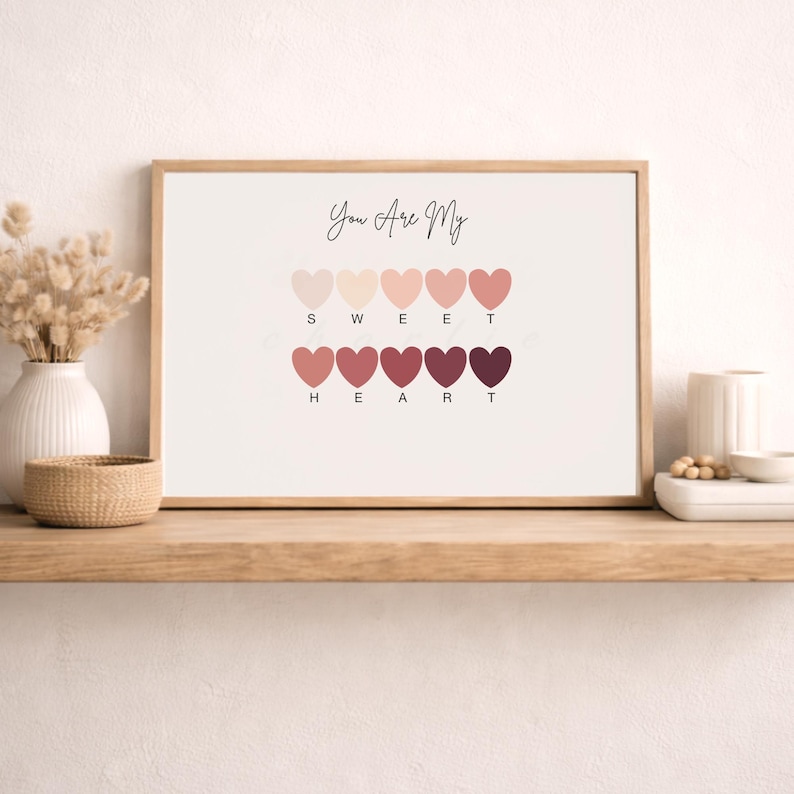 Puede incluir: Una impresi&oacute;n enmarcada con el texto "You Are My Sweet Heart" sobre una serie de formas de coraz&oacute;n en varios tonos de rosa y rojo. La impresi&oacute;n se muestra en una estanter&iacute;a de madera con objetos decorativos.