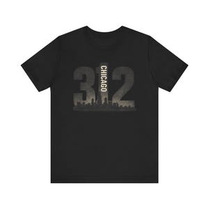 Puede incluir: Camiseta negra con un diseño gráfico desgastado. El diseño incluye el número "312" con la palabra "CHICAGO" alineada verticalmente en el centro. Una silueta del horizonte de la ciudad está en la parte inferior.